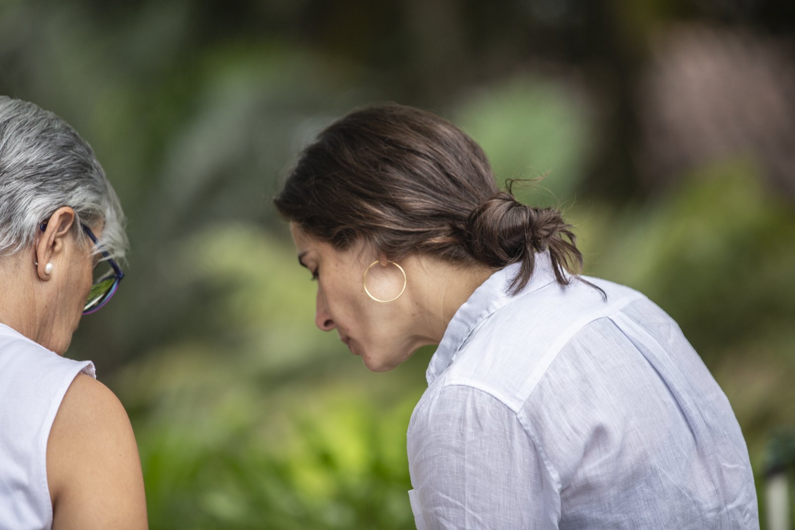 Two women in profile, heads bent close together