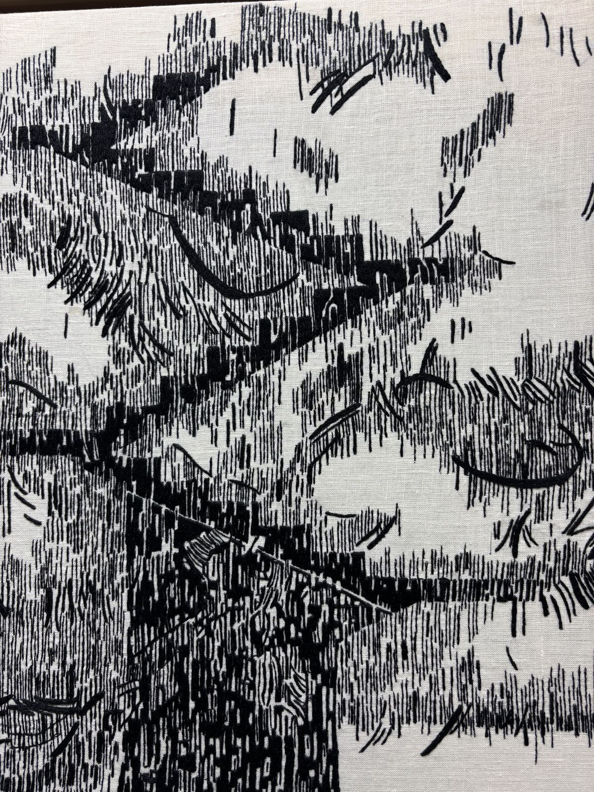 Close detail of black-thread stitching, angular branching lines
